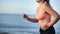 Closeup torso of muscular female athlete running on beach. Shot on RED Raven 4k Cinema Camera