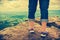 Closeup of tourist`s feet on boulder at view point. Cross proces