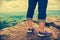 Closeup of tourist`s feet on boulder at view point. Cross proces