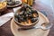 Closeup of traditional dish of French cuisine, appetizing seafood soup with  mussels served in ceramic plate.