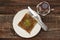 Closeup of traditional Turkish dessert - Kadayif with pistachio powder (Burma kadayif) on wooden background.