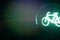 closeup on traffic light showing green bicycle symbol isolated at night with colorful dark background with moving light trail