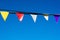 Closeup of triangle colorful banners against a clear blue sky