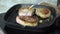 Closeup of turning pork chops in a cast iron grill