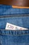 Closeup of twenty pounds sterling banknote peeking out of blue jeans back pocket