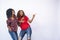 Closeup of two beautiful black women feeling excited and pointing to the empty space on their side