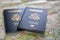 closeup of two blue US passports laying on road map of foreign country