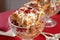 Closeup of two crystal goblets filled with Italian Panettone cranberry bread pudding with sauceboat in background