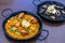 Closeup of two dishes of Paella and Arros negre served in a restaurant