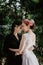 Closeup of two females hugging each other one with a brides dress and another black suit lipstick