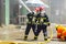 Closeup two firefighters of Lampang city confederate water spray and control the hoses