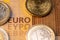 Closeup of two hundred Euro banknote surrounded by coins. EURO writing on bill in focus