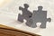 Closeup of two jigsaw puzzle pieces on book