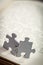 Closeup of Two Jigsaw Puzzle Pieces on Page of a Book