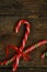 Closeup of two old fashioned candy canes on a rustic wooden back