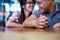 Closeup on two young lovers holding hands at a table, symbol sign sincere feelings, compassion, loved one, say sorry. Reliable