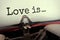 Closeup typed text Love is written on sheet of paper in a mechanical typewriter