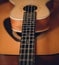 Closeup of a ukulele neck lying on guitar