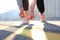 Closeup of unrecognizable sport woman tying sports shoes during evening run outdoors