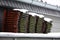 Closeup of used snow-covered roof tiles stacked on a carport