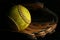 Closeup of a used, yellow softball resting on a leather glove.