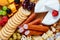 Closeup of various types of gourmet cheese slices with mold green black olives and walnuts on wooden platter over blurred