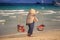 Closeup Vendor Woman with Yoke Walks along Beach against Sea