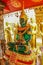 Closeup vertical shot of a green and golden statue of Budha