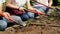 Closeup video of farmers holding gardening tools cultivating and shaping the soil on garden bed. TEamwork at countryside