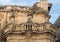 Closeup view of 3 saint statues on a balcony at the entrance to the Piazza del Duomo, Lecce