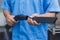 Closeup view of an anonymous person in a blue uniform attaching a crevice tool to a vacuum cleaner hose