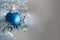 Closeup view of a blue matte ball hanging on a silver artificial Christmas tree with copy space for your text message