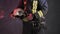 Closeup view of a brave firefighter in special uniform holds protective helmet standing against a gray wall