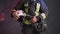 Closeup view of a brave firefighter in special uniform holds protective helmet standing against a gray wall