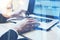 Closeup view of businessman working at sunny office on laptop.Male hands pointing on notebook keyboard.Blurred