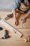 Closeup view of a carpenter using a red pencil to draw a line on a blueprint