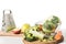 closeup view of cutting boards, grater, bowl, apples, carrot, broccoli and cauliflower on table