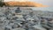 Closeup view of falling pyramid of pebbles on the picturesque Mediterranean sea coastline at morning