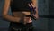 Closeup view of female hands being wrapped for boxing in dark room with smoke. Young fit woman wrapping hands with