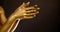 Closeup view of golden female palms moving in oriental dance, detail view of hands