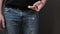 Closeup view of hand pull out a smart phone of rear jeans pocket. Close up