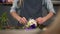 Closeup view of hands of a flower shop assistant tying a bunch of flowers lying on her table with the ribbon. Slowmotion