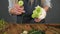 Closeup view of hands of professional blonde female floral artist arranging beautiful bouquet at flower shop. Floristry