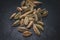 Closeup view of heap of cardamom seeds in black slate background. Spices of the world.