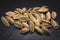 Closeup view of heap of cardamom seeds in black slate background. Spices of the world.