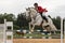 Closeup view of horseman in red jacket on a white horse