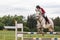 Closeup view of horseman in red jacket on a white horse