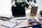 closeup view of laptop with blank screen at table with headphones, textbooks, coffee cup, photo frame, potted plant and roll of