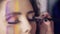 Closeup view of makeup artist makes models eye makeup with false eyelashes. Model with false lashes and face art