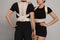 Closeup view of man and woman with orthopedic corsets on grey background